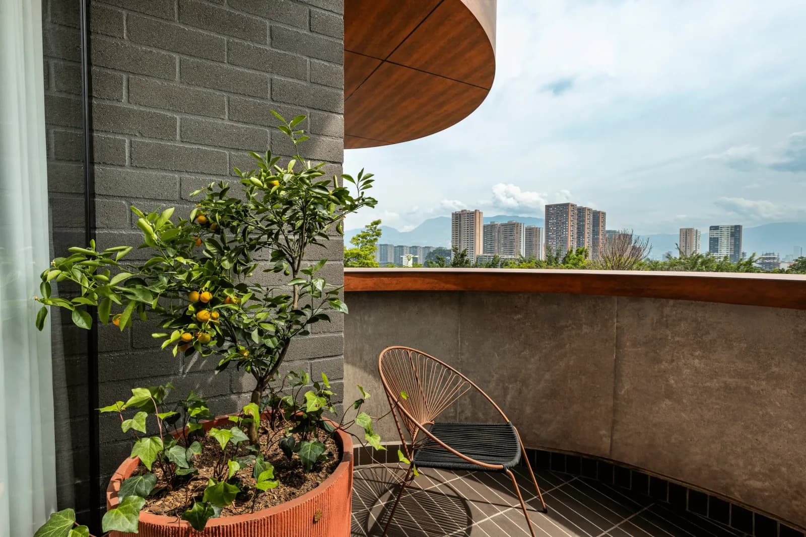 Balcón de HEISS Med, en Medellín, marca que el grupo impulsa como Growth partner de venta directa sin operarla, con materas, silla y vista a la ciudad.